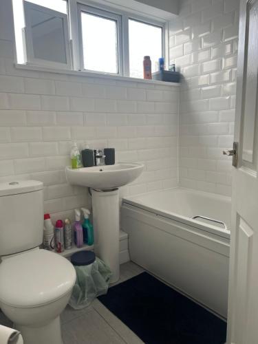 a bathroom with a toilet and a sink and a tub at Just Plan B Homes in Forest Hill