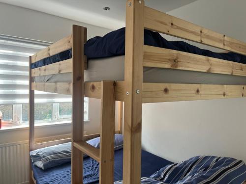 two bunk beds in a room with a window at Just Plan B Homes in Forest Hill