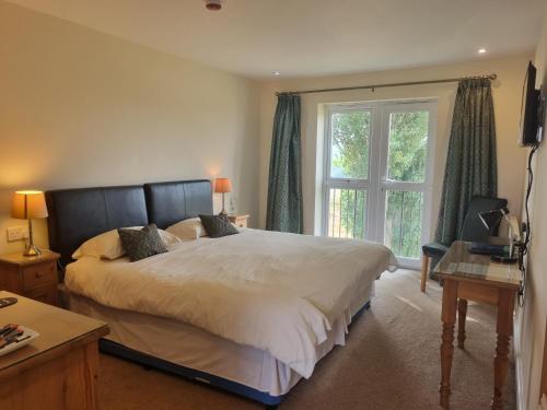um quarto com uma cama grande e uma janela em The Castle Inn em Market Drayton