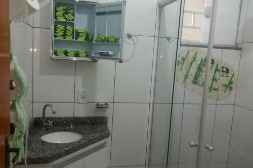 W łazience znajduje się umywalka i przeszklony prysznic. w obiekcie Casa em condomínio, churrasqueira privativa e piscina social w mieście Caldas Novas