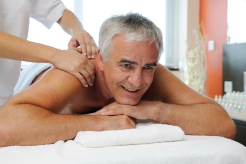 a man laying on a bed getting a massage at Hotel Astoria - Alexandra Krämer eK in Bad Füssing