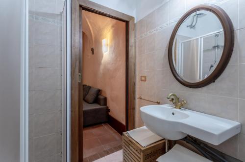 a bathroom with a sink and a mirror and a shower at casa Giovanna - Piazza San Michele Central Studio! in Lucca