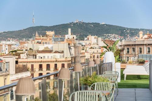 a balcony with chairs and a view of a city at Gran Hotel Havana 4Sup by Escampa Hotels in Barcelona