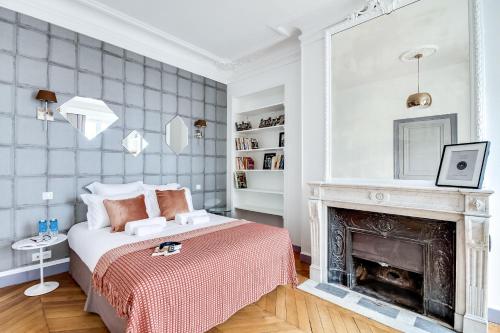 une chambre avec un lit et une cheminée dans l'établissement Sweett - Atelier Ponthieu, à Paris