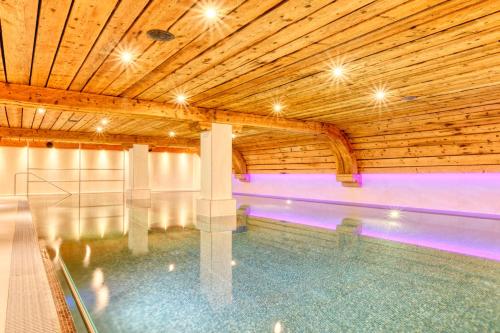 an indoor swimming pool with a wooden ceiling at Hotel Arca Solebad & Spa in Zermatt