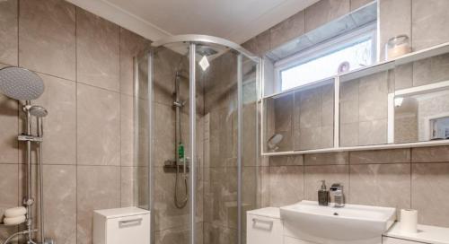 uma casa de banho com um chuveiro, um lavatório e um WC. em Extensive 4 bed close to Peterborough em Ramsey