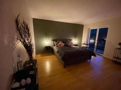 a bedroom with a bed and a large window at Eifel-Mosel-Hideaway in Landscheid