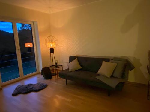 a living room with a green couch and a window at Eifel-Mosel-Hideaway in Landscheid