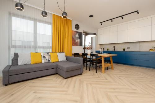 a living room and kitchen with a couch and a table at Cozy & Spacious Family Apartment by Renters in Warsaw