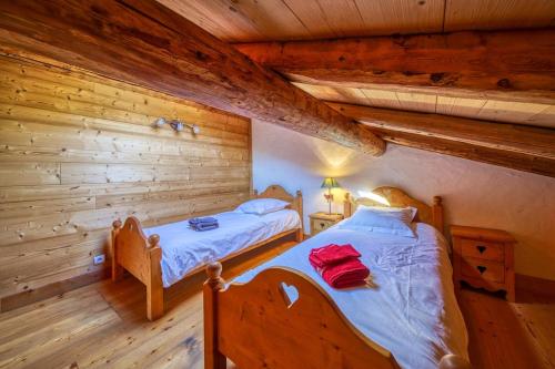1 dormitorio con 2 camas en una cabaña de madera en Chalet Beaufortain La Pachna, en Hauteluce