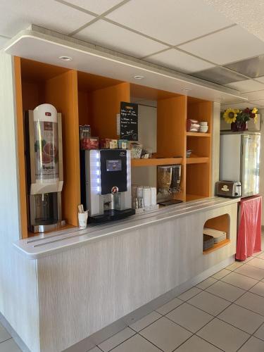 un café avec un comptoir avec une machine à café dans l'établissement Premiere Classe Angoulême La Couronne, à La Couronne
