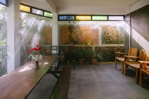 a restaurant with wooden tables and chairs and a brick wall at Private House - Pool - Best Location - Groups & Families ChiangMai in Chiang Mai