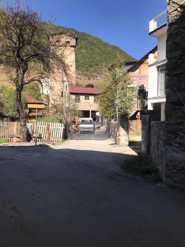 a parking lot with a house and a tree at Boutique hotel mestia in Mestia