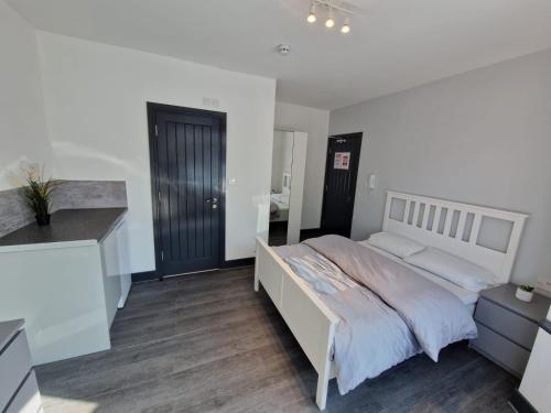 a bedroom with a large bed and a desk at Room On Southall High Street in Southall