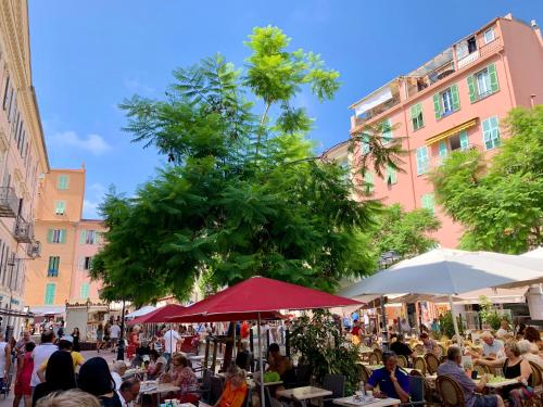 a crowd of people sitting at tables in a street at Studios - Menton Old Town - near the beach and shops in Menton
