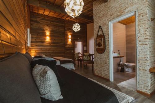 a living room with a bed and a dining room at Pousada Canto da Nascente in Monte Verde
