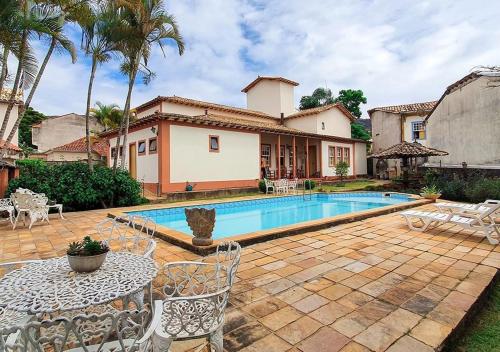 ein Hinterhof mit einem Swimmingpool und einem Haus in der Unterkunft Pousada Quinta Do Conde in Tiradentes