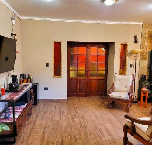 ein Wohnzimmer mit einer Tür und einem Stuhl und Holzböden in der Unterkunft ALQUILER TEMPORARIO EN PURMAMARCA in Purmamarca