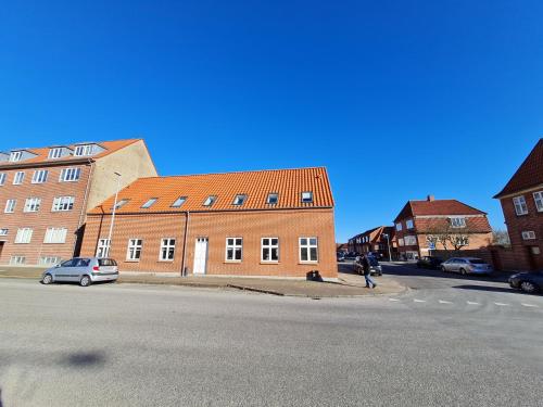 a person walking on a street next to a brick building at (id024) Østergade 87. 1 tv in Esbjerg
