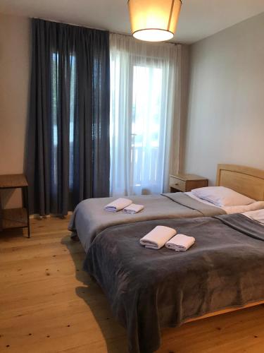 a bedroom with a large bed with two towels on it at Boutique hotel mestia in Mestia