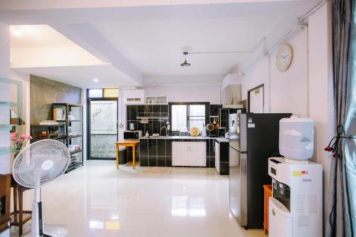 a kitchen with a black refrigerator and a white floor at Private House - Pool - Best Location - Groups & Families ChiangMai in Chiang Mai