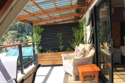 a patio with a pergola and chairs on a deck at Pelican Lodge Guesthouse in Sedgefield