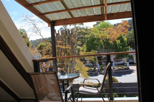 a balcony with a table and chairs and a view at Pelican Lodge Guesthouse in Sedgefield