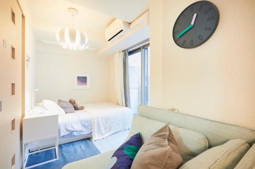 a living room with a couch and a clock on the wall at shinjuku1 in Tokyo