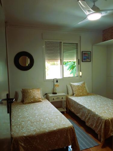 a bedroom with two beds and a window at Las Palmeras in Alberique