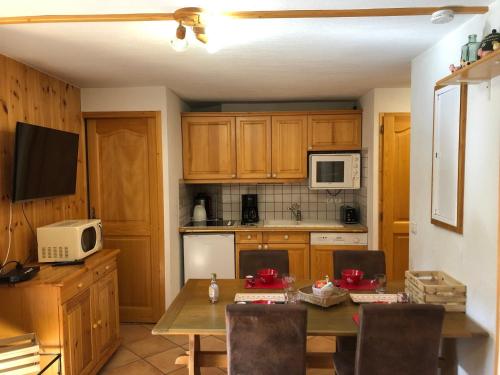 - une cuisine avec une table et un four micro-ondes dans l'établissement Charmant T2 cabine pour 4 près du centre et commerces à Méribel, parking inclus - FR-1-411-677, à Les Allues