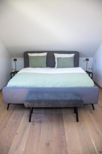 een slaapkamer met een groot bed en een houten vloer bij Elmi 33 in Wals