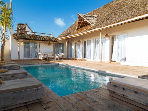 a villa with a swimming pool and a house at Limiria Villa Zanzibar in Nungwi