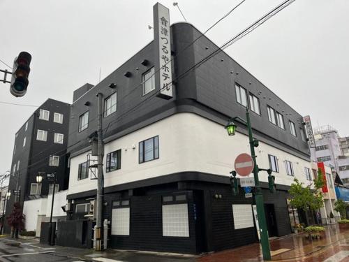 a black and white building on the corner of a street at Aizu Tsuruya Hotel - Vacation STAY 57216v in Aizuwakamatsu