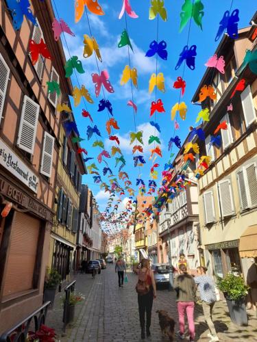 a group of people walking down a street with kites at LOVE ROOM Le rouge et noir in Barr