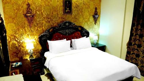 een slaapkamer met een bed met een rood hoofdeinde bij Hotel Leaders Plaza Mahboula in Koeweit