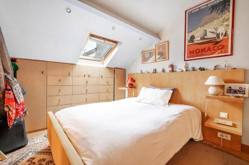 une chambre avec un grand lit blanc et une fenêtre dans l'établissement Veeve - Reader's Retreat, à Paris