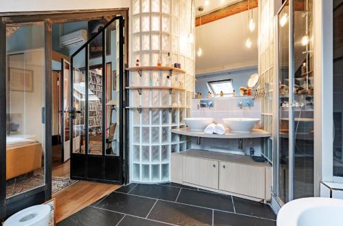 - une salle de bains avec deux lavabos dans l'établissement Veeve - Reader's Retreat, à Paris