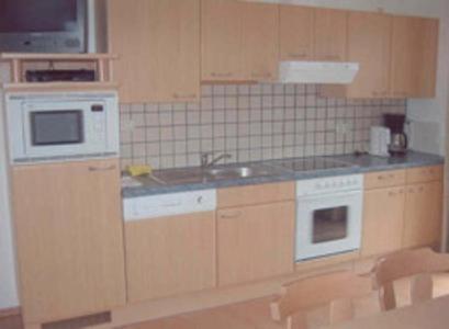 a kitchen with wooden cabinets and a sink at Hansalagut in Mauterndorf
