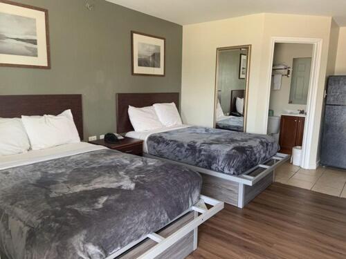een hotelkamer met 2 bedden en een spiegel bij Paris Extended Stay Suites in Paris