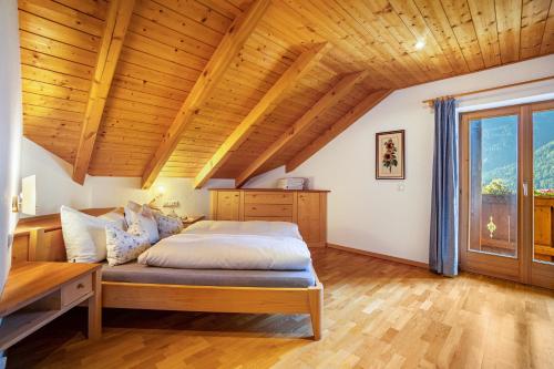 een slaapkamer met een bed en een houten plafond bij Adults Only Wasserfall Hegedex in Fundres