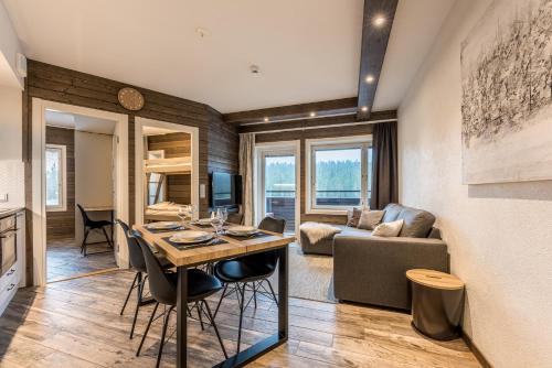 een keuken en een woonkamer met een tafel en een bank bij RukaValley Unique47 Ski In - Ski Out in Ruka