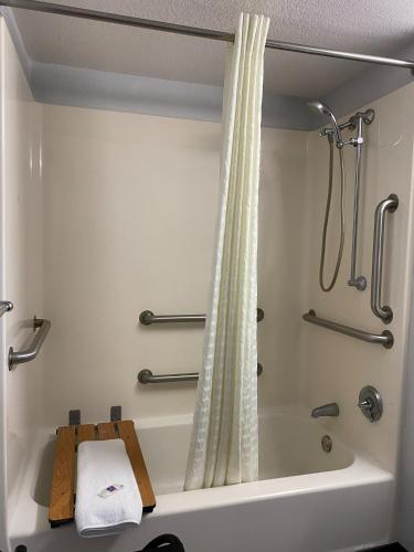 a bathroom with a bath tub with a shower curtain at Motel 6-Lantana West Palm Beach, FL in Lantana