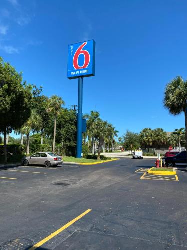 a gas station sign in a parking lot with a car at Motel 6-Lantana West Palm Beach, FL in Lantana