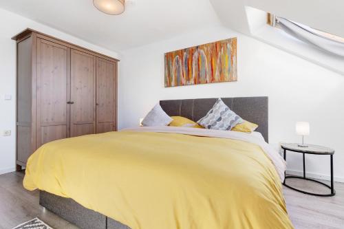 a bedroom with a bed with a yellow blanket at Künzes Domizil in Edemissen
