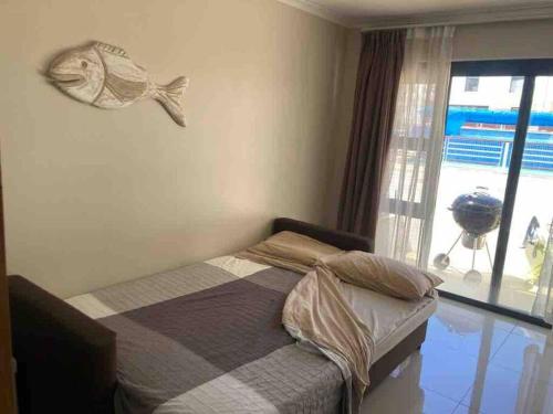 a bedroom with a bed with a fish on the wall at Appartamento Azure 23 - Big Bay in Big Bay
