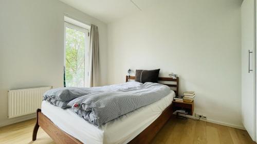 sypialnia z łóżkiem i oknem w obiekcie ApartmentInCopenhagen Apartment 1565 w Kopenhadze