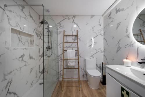 een badkamer met een douche, een toilet en een wastafel bij Apartamento Rodrigo in Covilhã
