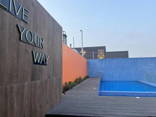 a swimming pool with a sign on the side of a building at Departamento Acogedor "El Polo" - 3 Min Frente a embajada USA in Lima