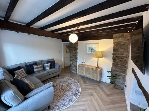 a living room with a couch and a table at Lavender Cottage with a hot tub in Deganwy