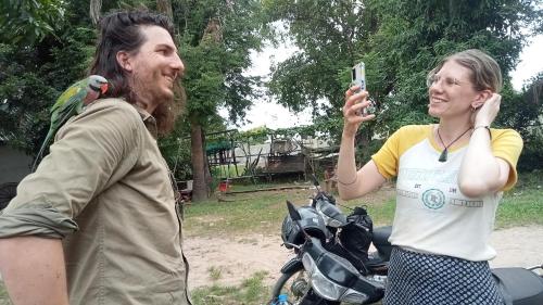 a man taking a picture of a woman on a motorcycle at Meta Homestay in Phumĭ Puŏk Chăs